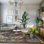 Modern living room with a colorful traditional floral hand knotted rug, gray sofa, yellow chair, and decorative plants.