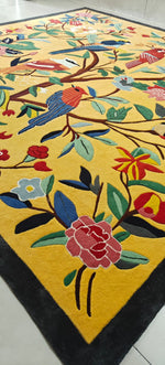 Colorful rug with floral and bird design on a yellow background