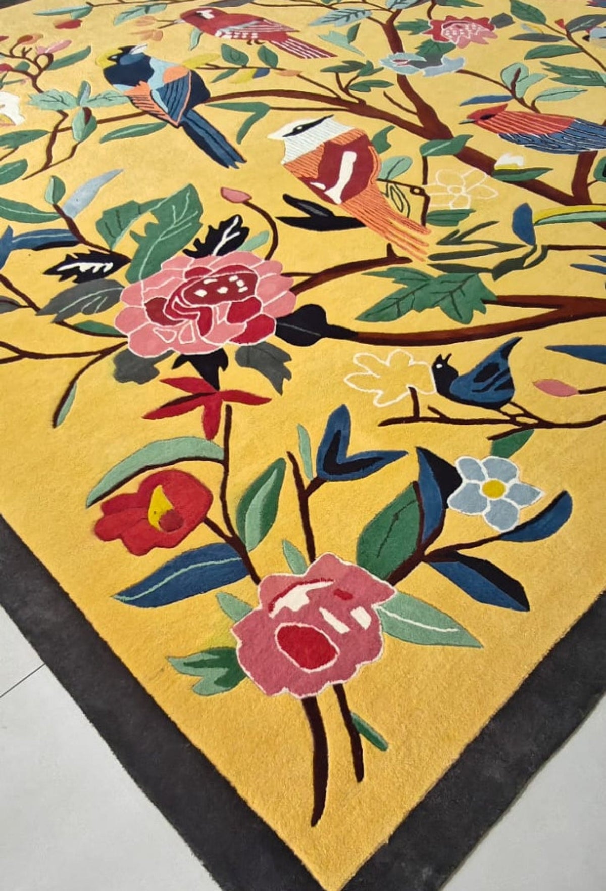 Decorative rug with floral and bird patterns on a yellow background