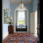 A beautifully designed floral fusion hand tufted area rug in a light-filled hallway, showcasing vibrant floral patterns. Ideal as a square area rug for offices or large living rooms, this vintage wool rug adds a touch of elegance and color to any space.