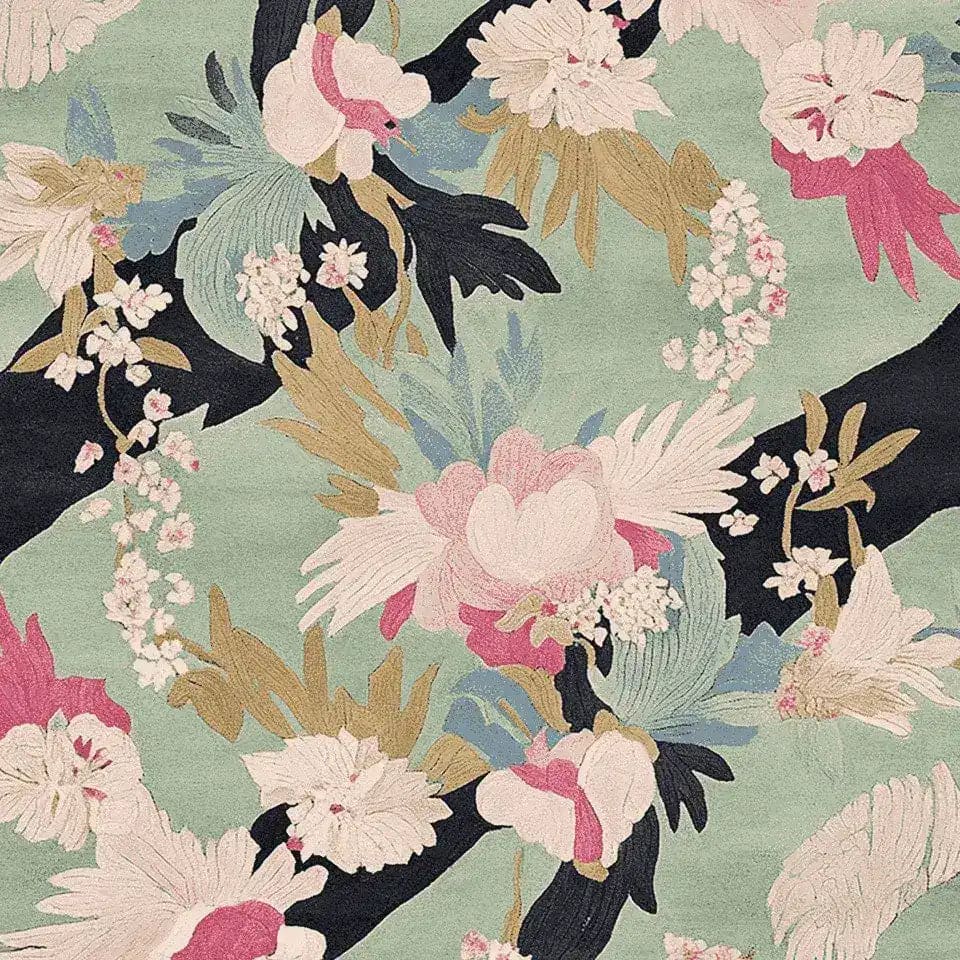 A beautifully designed area rug showcasing a floral pattern with vibrant pink, white, and green hues. This wool rug is perfect for adding a touch of elegance to your living room area, combining both style and comfort in one piece.