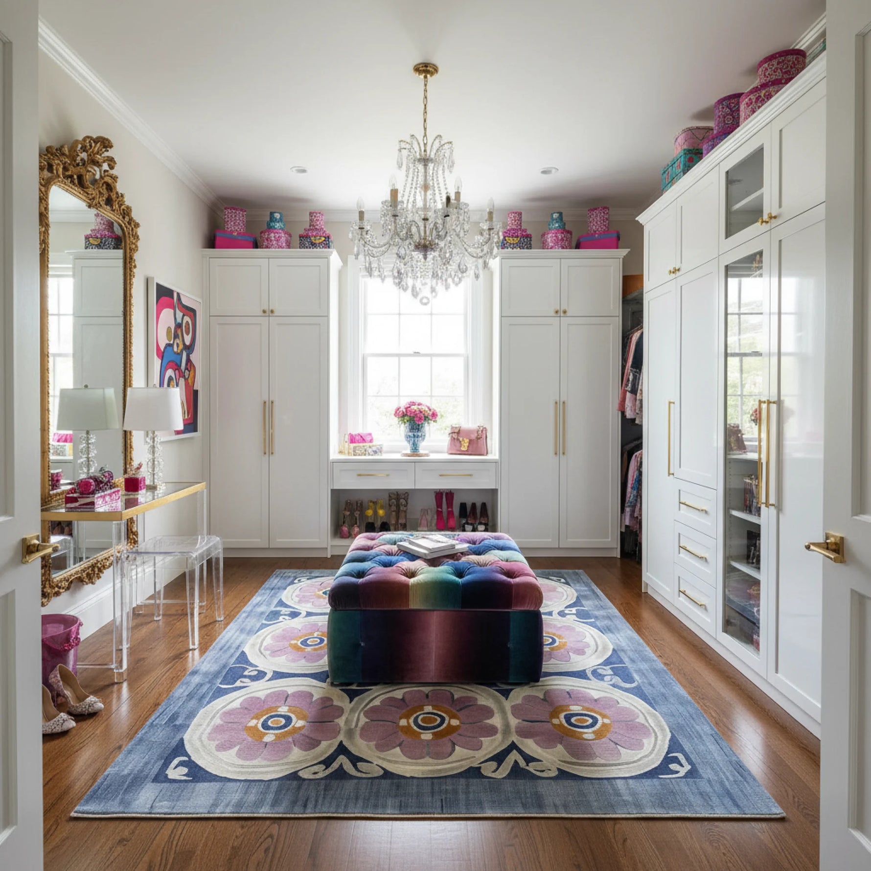 Modern room with a colorful rug, ottoman, and white cabinets.