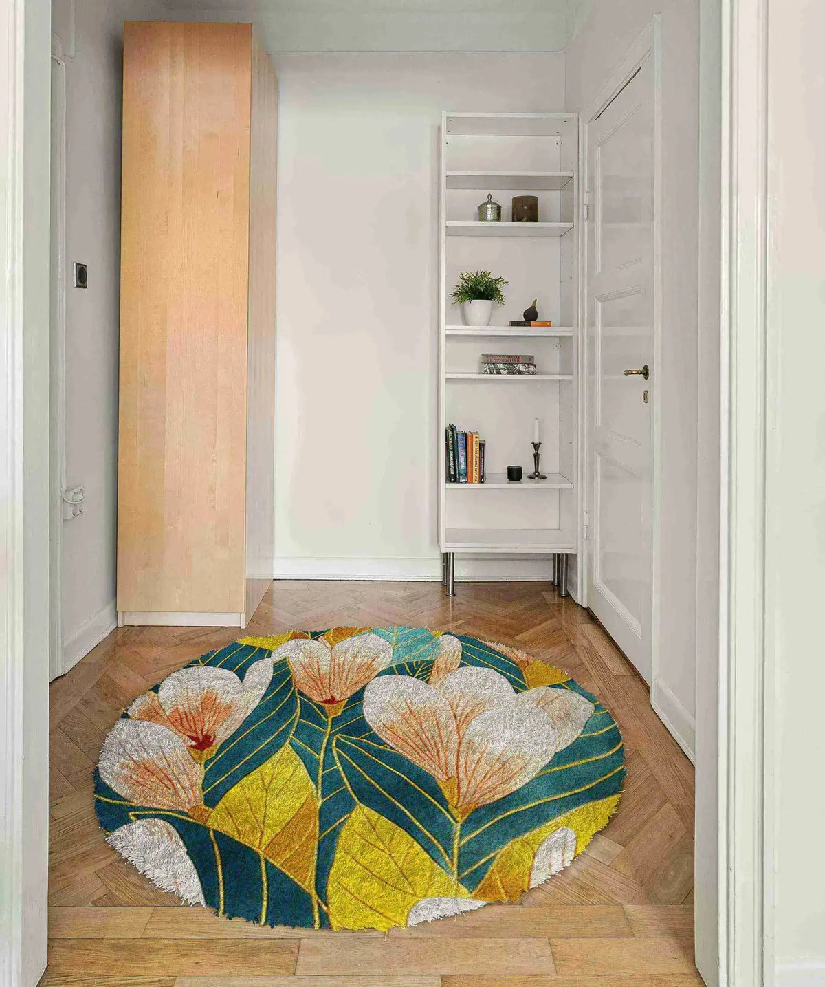 A vibrant round area rug featuring a floral pattern in shades of blue, yellow, and white, adding a touch of elegance to a modern bedroom setting. This hand-tufted wool rug complements the wooden floor, making it ideal for bedrooms or living rooms as an 8x10 floral rug centerpiece.