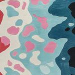 Close-up of a contemporary hand-tufted wool rug featuring an abstract pattern in vibrant colors like red, pink, blue, and black. Perfect for large living rooms or dining tables, this area rug adds a modern touch to any dining room or living room.