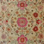 The Flower Enchantment Hand Knotted Area Rug features a stunning floral design with vibrant pink and red blooms set against a beige background. Perfect for those seeking large living room rugs with a vintage feel, this Persian-inspired floral rug adds elegance and charm to any living room area.