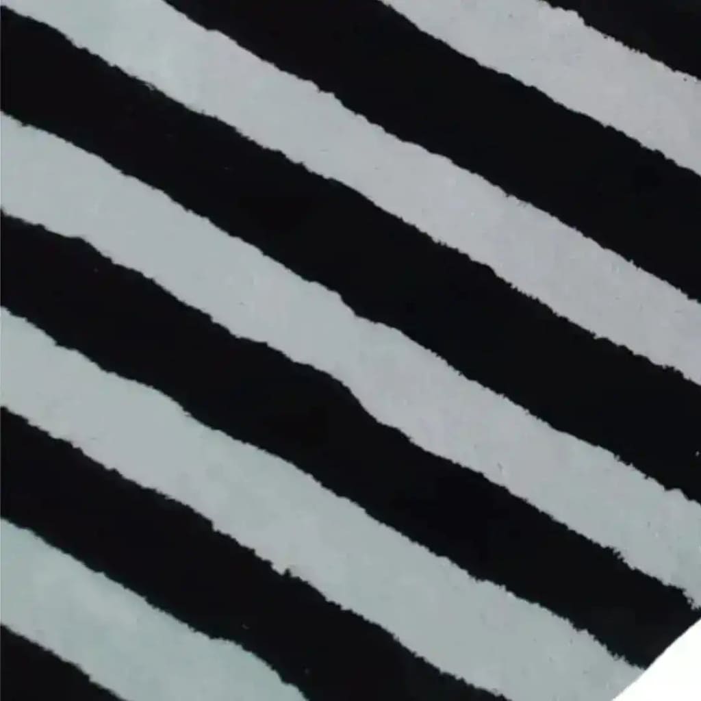 Close-up of the Flowing Illusion Black and Gray Wool Runner Rug, showcasing its bold black and gray striped pattern. Perfect as a contemporary area rug for dining rooms, kitchens, or living rooms. This vintage-inspired wool rug adds elegance to any space, whether used as a hallway runner, kitchen runner, or living room area rug.