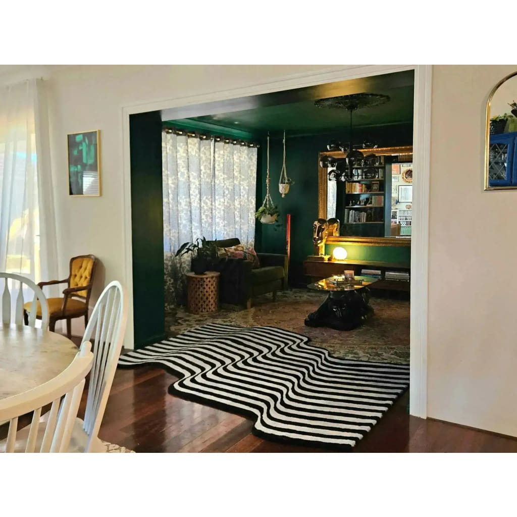 A stylish living room featuring a Flowing Illusion Black and Gray Wool Runner Rug with an abstract design. This contemporary area rug complements the vintage decor, adding a modern touch to the dining room and hallway. Perfect as a wool rug for kitchens, large living rooms, or as a hallway runner rug, this elegant piece enhances any space with its unique pattern.