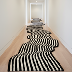Black and white striped rug on a wooden floor in a hallway
