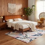 Cozy bedroom with wooden bed, floral rug, and decorative elements.