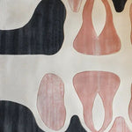 Contemporary area rug featuring an abstract design with black and blush patterns on a cream background, showcasing the texture of a hand-tufted wool rug. Perfect for adding a modern touch to large living room spaces.