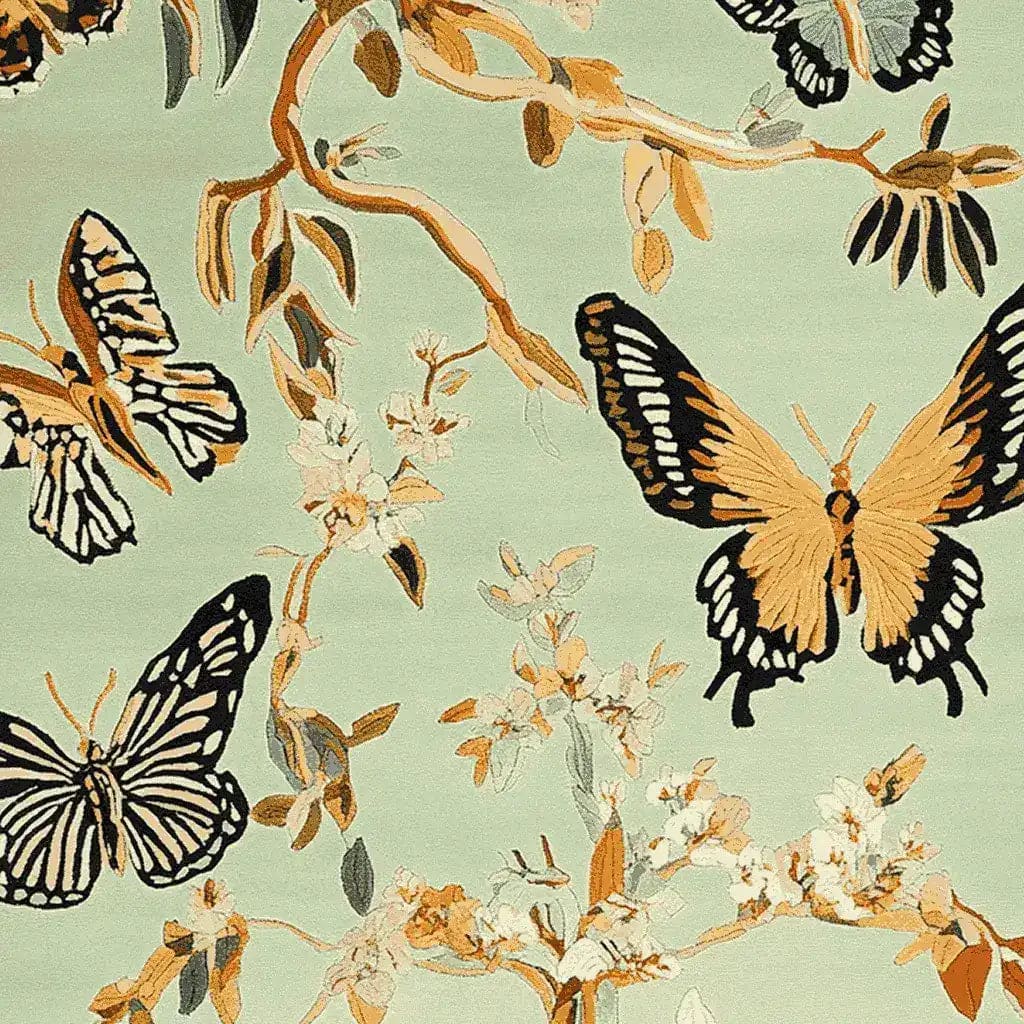 A beautifully detailed hand-tufted area rug showcasing a vibrant design of butterflies and branches. This wool rug, perfect for enhancing large living room spaces, features intricate patterns in earthy tones against a soft green background.
