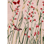 A vibrant area rug depicting a meadow scene with red and pink flowers and playful butterflies on a soft pastel background. This wool rug, ideal for large living rooms, adds a touch of nature's beauty to your space, fitting perfectly in an 8x10 setting.