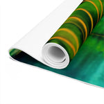 Foam yoga mat rolled up showing green lotus pond print surface and white core