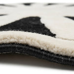Close-up of a black and white patterned rug with visible texture.