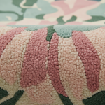 Close-up of a textured fabric with pink, green, and beige colors.