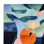 This vibrant, contemporary area rug features an abstract design with bold colors like orange, blue, and green, creating a fragmented garden bloom effect. Ideal as a square wool rug for large living rooms, this hand-tufted rug adds a splash of modern art to your space, making it perfect for those seeking unique area rugs for living room decor.