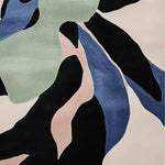Close-up view of the Fragmented Nature Flow Hand Tufted Area Rug showcasing its contemporary abstract design in shades of black, blue, green, and pink. This wool rug is perfect for adding a modern touch to living room area rugs, especially in an 8x10 size.