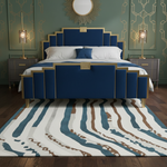 Decorative bedroom with a blue bed, patterned rug, and wall mirror.