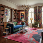 Living room with a red rug, colorful furniture and decor