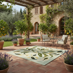 Outdoor patio with a patterned rug, chairs, and a table in a garden setting.