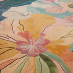 Close-up of a colorful floral rug pattern with pink, yellow, and green flowers.