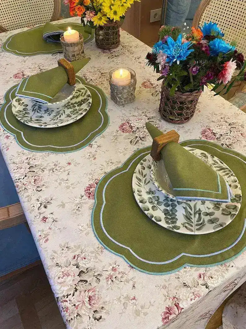 Garden Grove placemats overview on table, two olive green scalloped ovals with blue trim, botanical china, colorful flowers