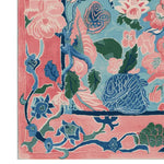Close-up view of the Garden of Legends Hand Tufted Rug, showcasing a vibrant floral design in pink, blue, and green hues. This wool square area rug is perfect for adding a touch of elegance to any living room, making it a standout piece among large living room rugs.