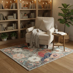 Cozy living room with a beige armchair, floral rug, and bookshelves.