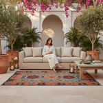 Woman sitting on a beige sofa in a patio with decorative rug, plants, and lanterns.