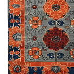 Close-up view of the Garden of Tradition Hand Tufted Area Rug, showcasing its intricate floral design with vibrant orange and navy blue hues. This wool rug is perfect for large living rooms or office spaces, adding a touch of elegance and tradition.