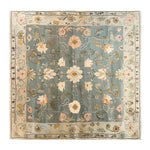 A beautifully designed area rug with an intricate floral pattern, the Garden Serenity Knotted Wool Rug showcases delicate pink and beige blooms against a soothing blue background. Ideal for enhancing living room spaces, this wool rug adds a touch of elegance and serenity to any home decor.