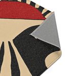 Corner fold of Geometric Sunburst Accent Rug showing cream black radial print and grey anti-slip backing with overlock stitching