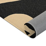 Rolled edge side view of Geometric Sunburst Accent Rug exposing grey anti-slip backing and overlock seam with cream black fabric