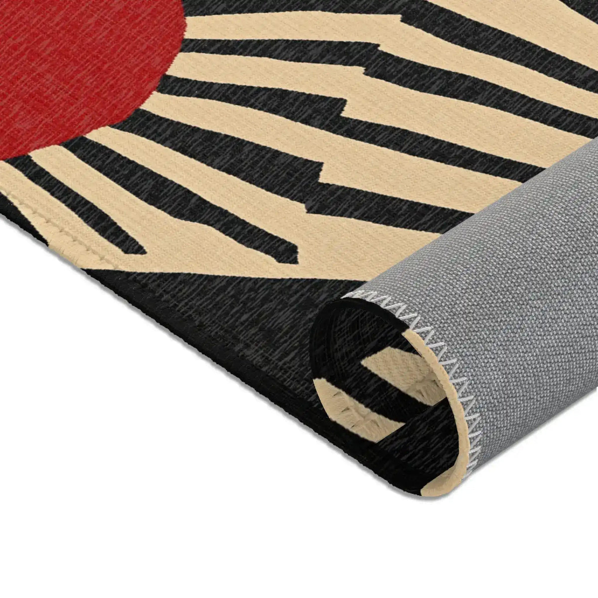 Rolled edge of Geometric Sunburst Accent Rug revealing grey non-slip backing and black cream fabric cross-section with zigzag seam