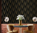 Gilded Grandeur Art Deco wallpaper in dining nook; gold fan pattern, dark table with wood chairs, white calla lilies in gold vase