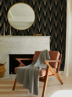 Gilded Grandeur wallpaper behind marble fireplace; round gold mirror above mantel, terracotta leather armchair with grey throw