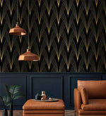 Gilded Grandeur wallpaper above navy paneling; copper pendants, tan leather armchair and ottoman, copper tray accessories