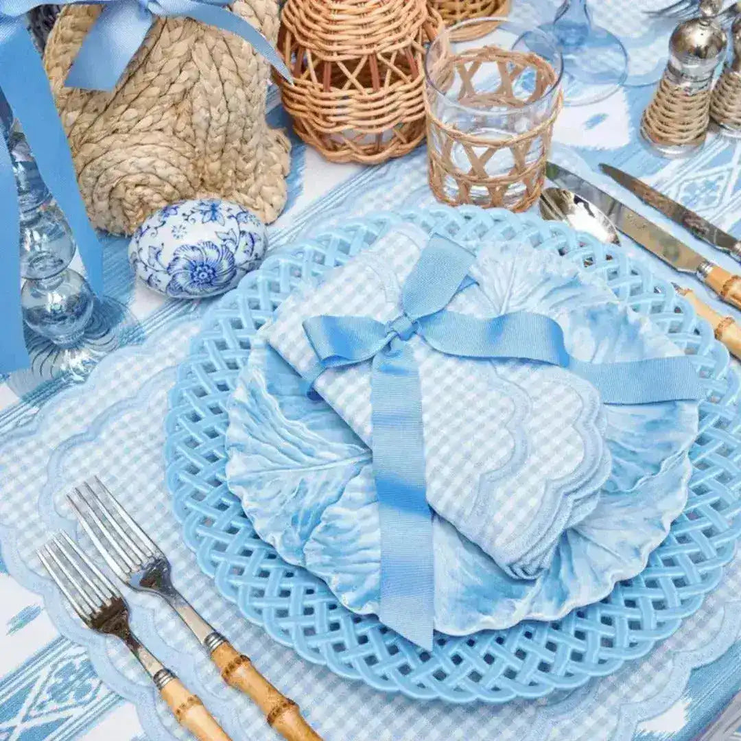 blue gingham scalloped-edge placemat at coastal table with lattice charger, ribbon napkin and rattan accents