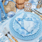blue gingham scalloped-edge placemat at coastal table with lattice charger, ribbon napkin and rattan accents