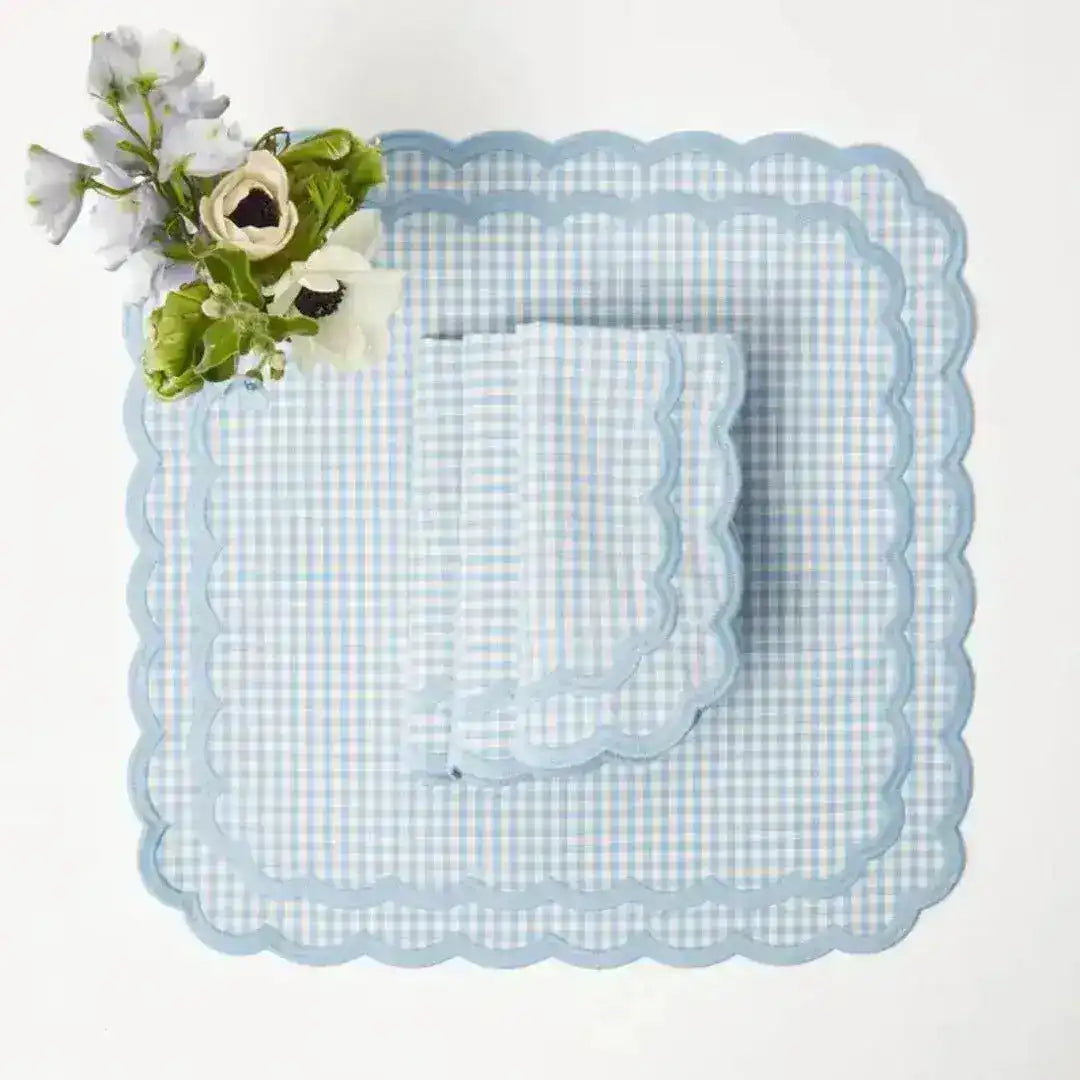 pale blue gingham scalloped-edge placemat square with matching napkin and white anemone bouquet, overhead