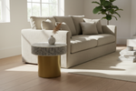 Gold base bone inlay geometric round accent table with a patterned top beside a cream sofa.