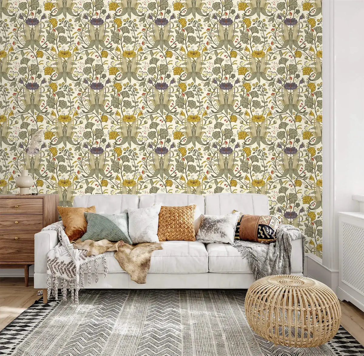 Vintage yellow floral wallpaper with green and purple botanicals on cream behind a white tufted sofa and rattan pouf