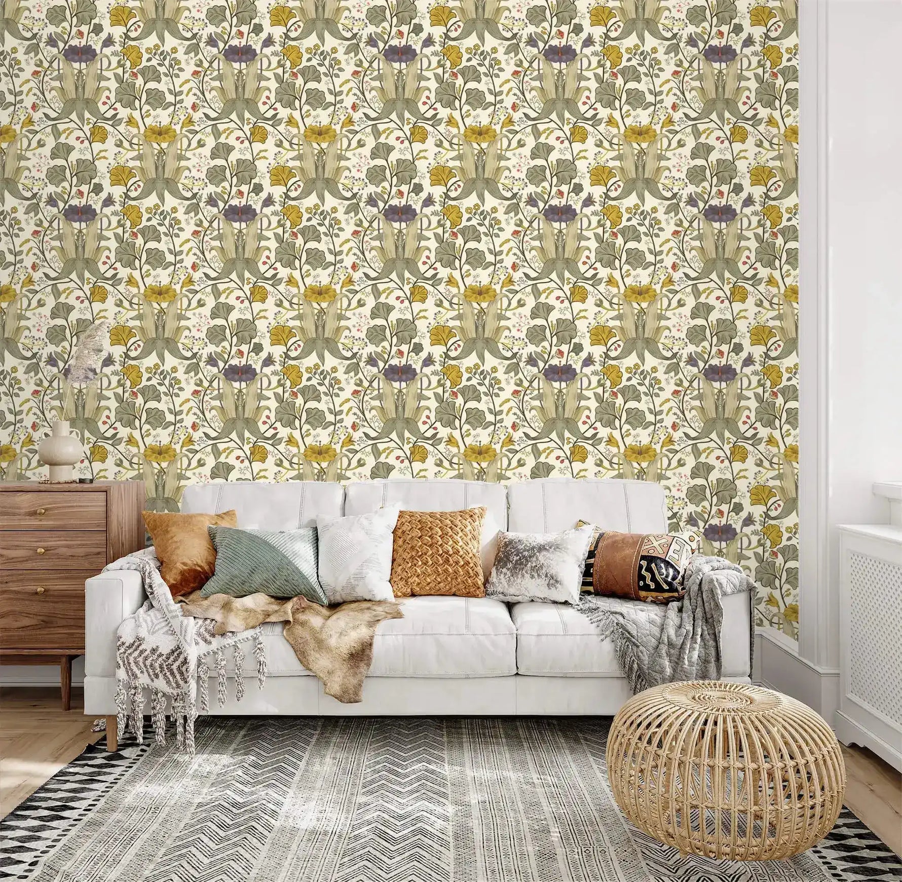 Vintage yellow floral wallpaper with green and purple botanicals on cream behind a white tufted sofa and rattan pouf