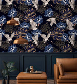 Golden crane flight wallpaper over navy paneling with copper pendants, white cranes among blue peonies
