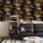 Black leather sofa and shelf set against golden creeper vine wallpaper above white panelling