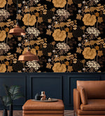Copper pendants and tan leather chair against golden creeper vine wallpaper over navy panelling