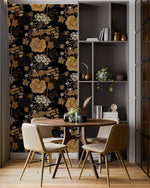Dining nook with round table beside a panel of golden vine wallpaper and grey shelving