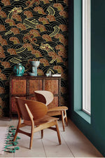 Golden dragon waves wallpaper accent wall with wood chairs, carved cabinet and teal vases by window