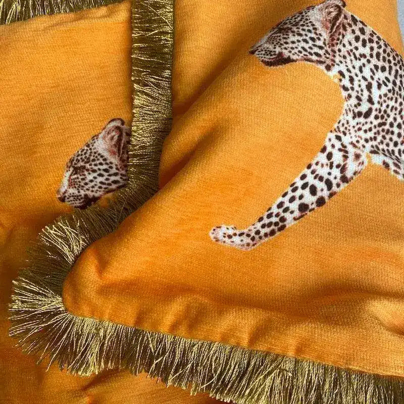 Golden fringe leopard throw pillow cover featuring a vibrant orange background and leopard print designs, perfect for adding a touch of wild elegance to your home decor.