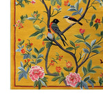 The Golden Garden Hand Tufted Area Rug showcases a vibrant floral design with birds perched on branches against a rich golden backdrop. Perfect for adding a touch of nature to your bedroom, this wool rug offers a luxurious and colorful statement piece among bedroom rugs.